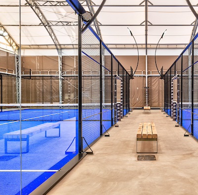 A modern racquet sports venue with multiple outdoor padel courts and supporting facilities